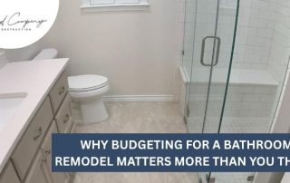 Modern bathroom with white vanity, toilet, and glass-enclosed shower; text overlay reads, “Why budgeting for a bathroom remodel matters more than you think!”.